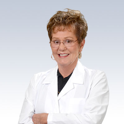 Becky Israel, a hearing care professional, wearing a white coat.