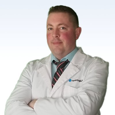 hearing care professional in a white lab coat with a HearingLife logo
