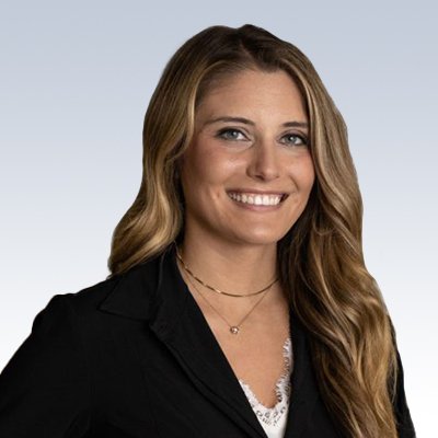 chelsea poffenberger, hearing care professional with long wavy blonde hair wearing a black blazer and layered necklaces