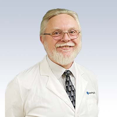 hearing care professional wearing a white lab coat with a tie, representing HearingLife clinic