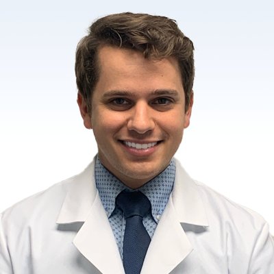 hearing care specialist wearing a white coat and blue tie