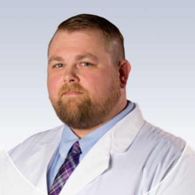 David Wyatt, hearing care specialist in a white lab coat and purple tie.