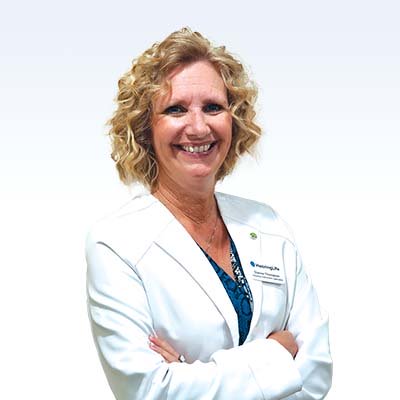 Hearing care professional in a white lab coat with arms crossed.