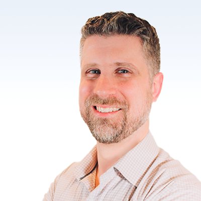 eric gilbert, hearing care specialist, wearing a light-colored checkered shirt against a gradient blue and white background