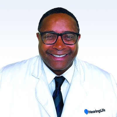 Hearing care professional Erik Buford in a white coat with a HearingLife logo.