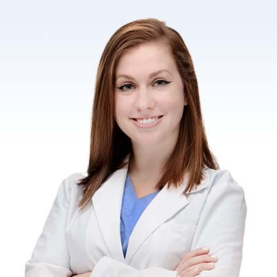 hearing care specialist in lab coat with arms crossed