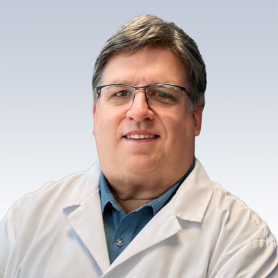 hearing care professional in a white coat with a neutral background