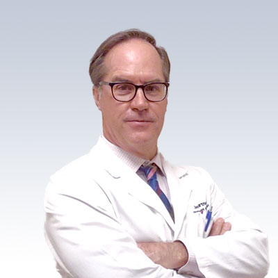 Jeff Hartney wearing a white lab coat with arms crossed against a light background.