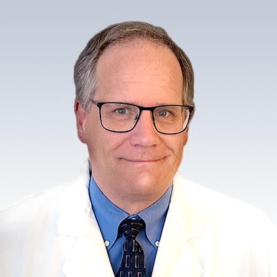 Jeffrey Snodgrass, hearing care professional wearing a white coat and blue shirt with tie