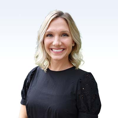 Kaitlin Blake, hearing care specialist, wearing a black blouse with a background gradient.
