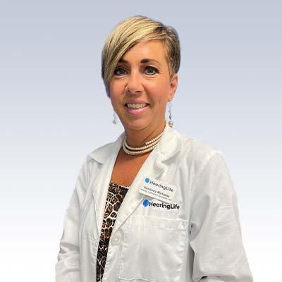 Kimberly Michalak, hearing care professional at HearingLife wearing a white lab coat with name tags.