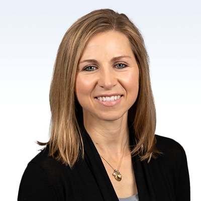 Kristin Hale, hearing care professional wearing a black cardigan and gold necklace, with shoulder-length blonde hair