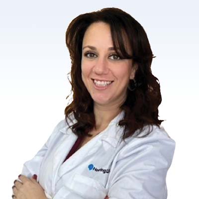 hearing care professional wearing a white coat with arms crossed