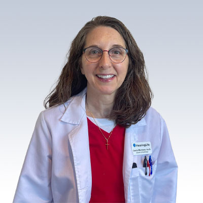 Laura Morrison, hearing care professional wearing a lab coat with a name badge from Hear4Life.