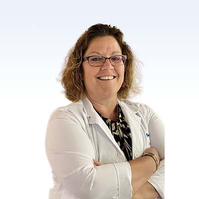 Hearing care professional in a white lab coat with arms crossed.