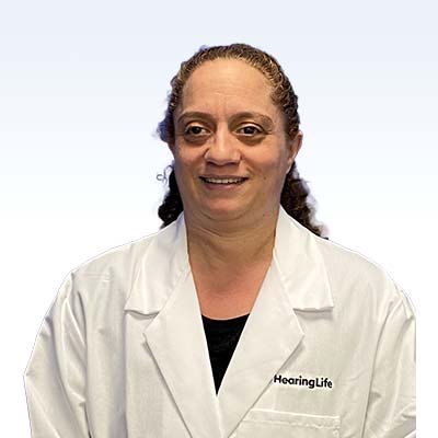 Maria Hacker, hearing care specialist at HearingLife, wearing a white lab coat.