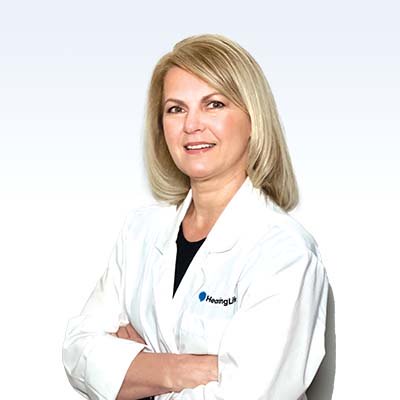 hearing care specialist wearing a white lab coat with arms crossed