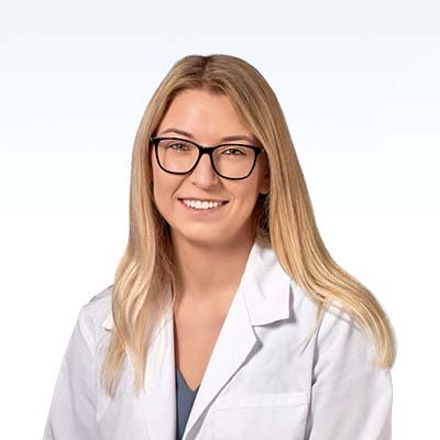 Megan Burton, hearing care professional wearing a white coat against a light background