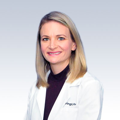 Melanie Friend wearing a HearingLife lab coat.