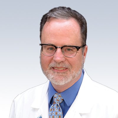 Mike Langer, hearing care specialist wearing a white coat and patterned tie.