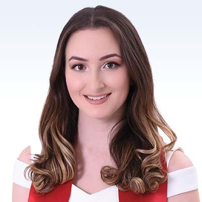 Miranda Velasquez wearing a white and red outfit with styled brown and blonde hair against a light gradient background.