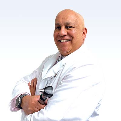 hearing care professional holding an otoscope wearing a white coat