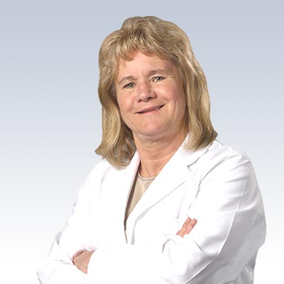 Niki Beckord wearing a white lab coat with arms crossed.