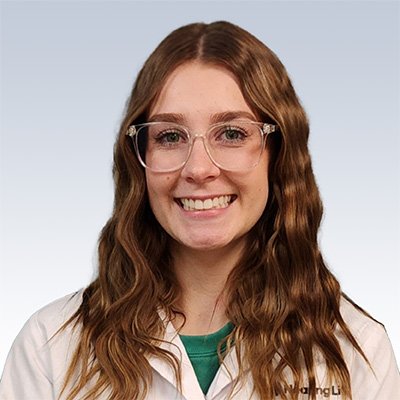 Samantha Spannbauer, hearing care professional wearing a white coat, with long wavy brown hair against a gradient background.