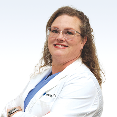 Hearing care professional in a white coat with 'HearingLife' branding