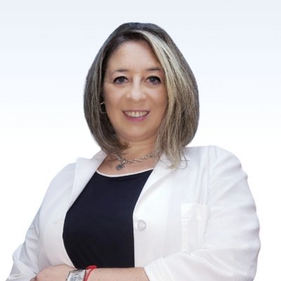 Hearing care professional in a white coat with crossed arms