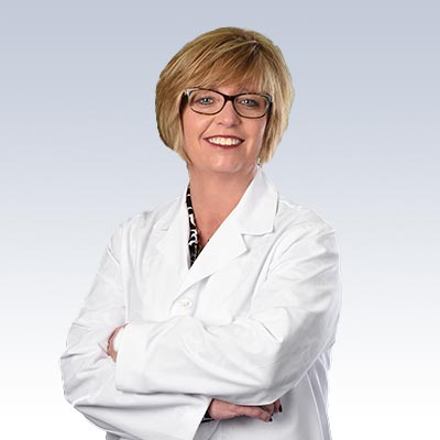 Taunya Hough wearing a white lab coat with arms crossed.