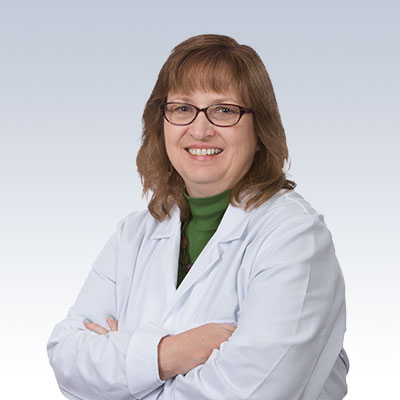 Theresa Simkevich wearing a white lab coat with arms crossed.