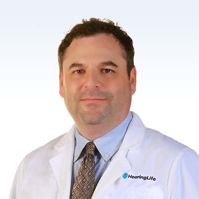 HearingLife professional in white coat and tie.