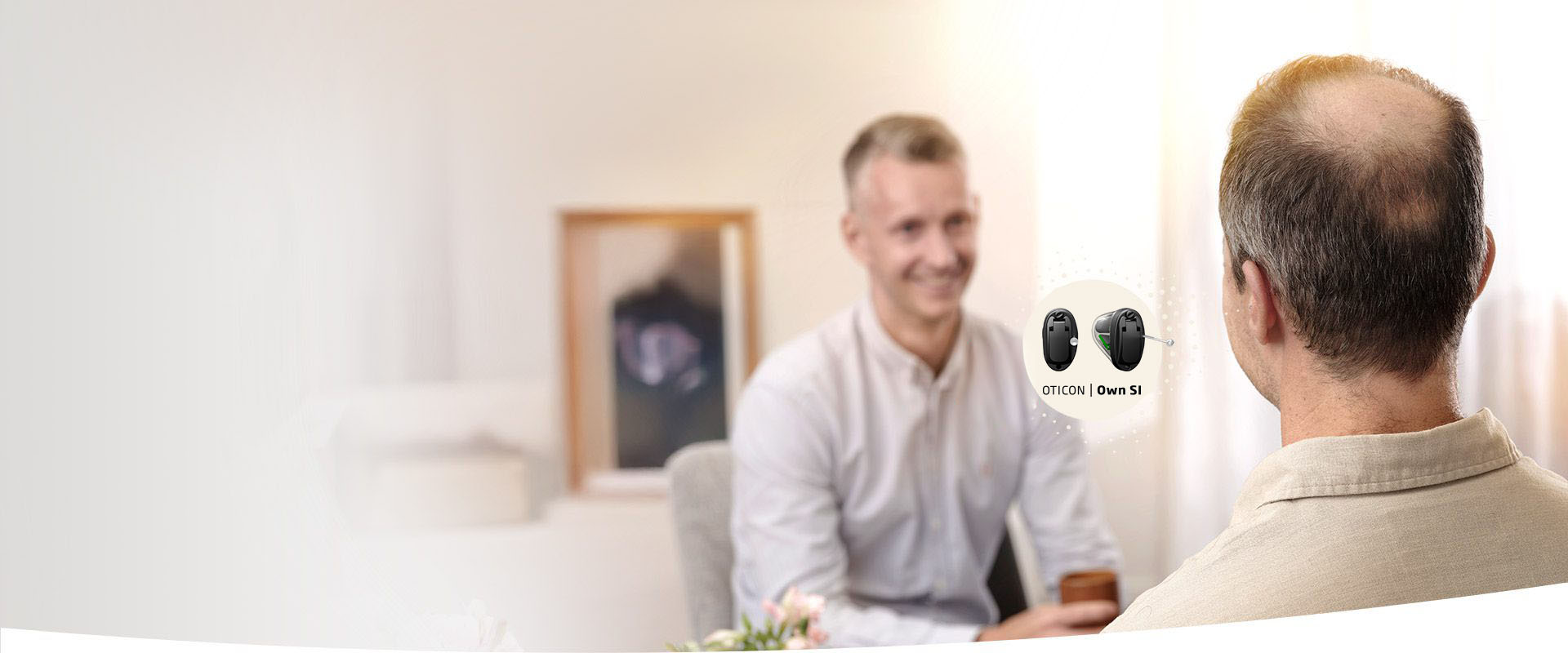 Oticon OWN SI™ hearing aid being discussed during a consultation.