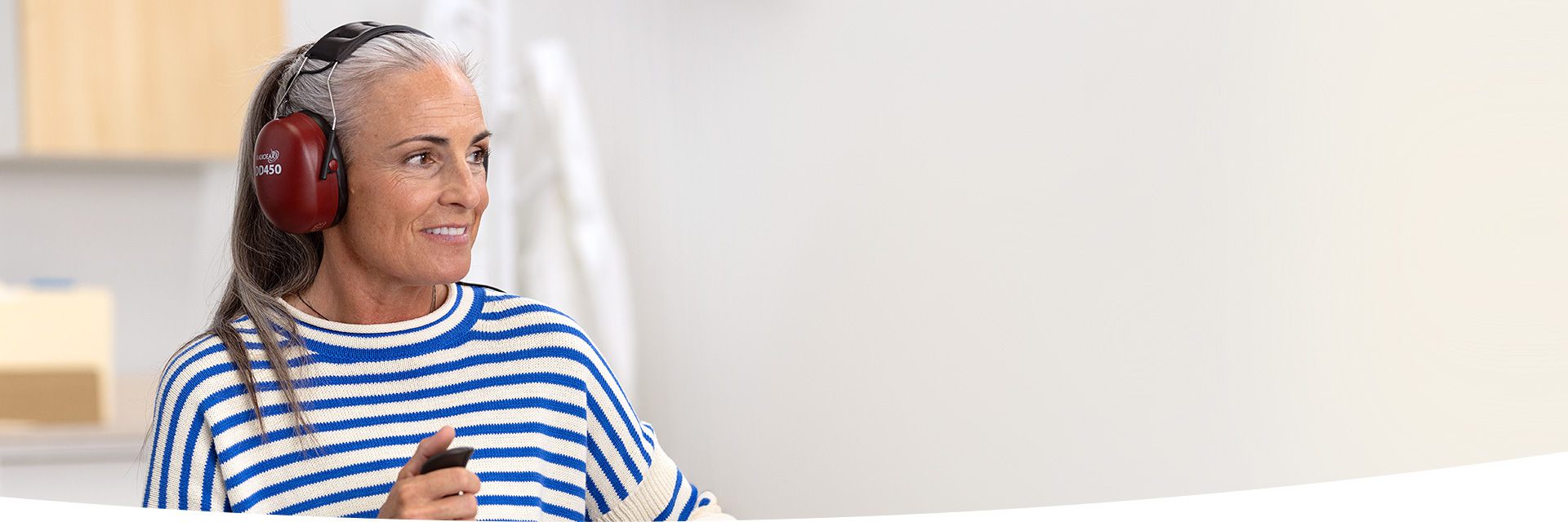 Woman smiling and taking hearing test with headphones