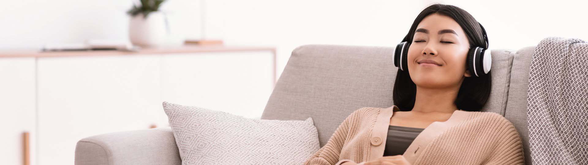 Relaxation through sound therapy with headphones in a comfortable home setting.