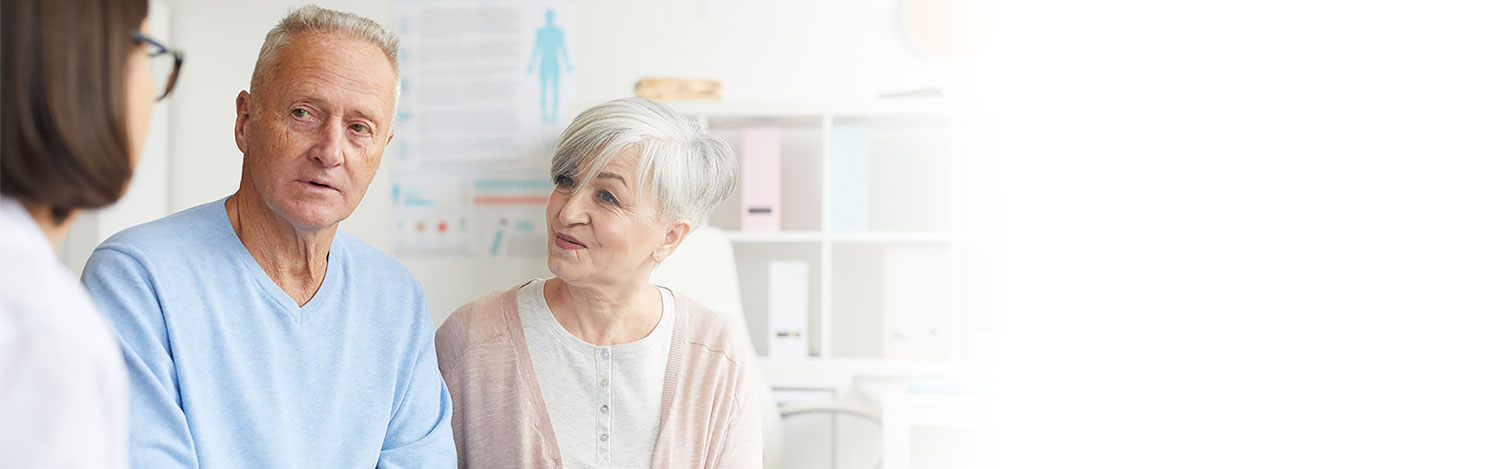 Man and woman discussing hearing care options with a HearingLife audiologist in a bright, modern clinic.