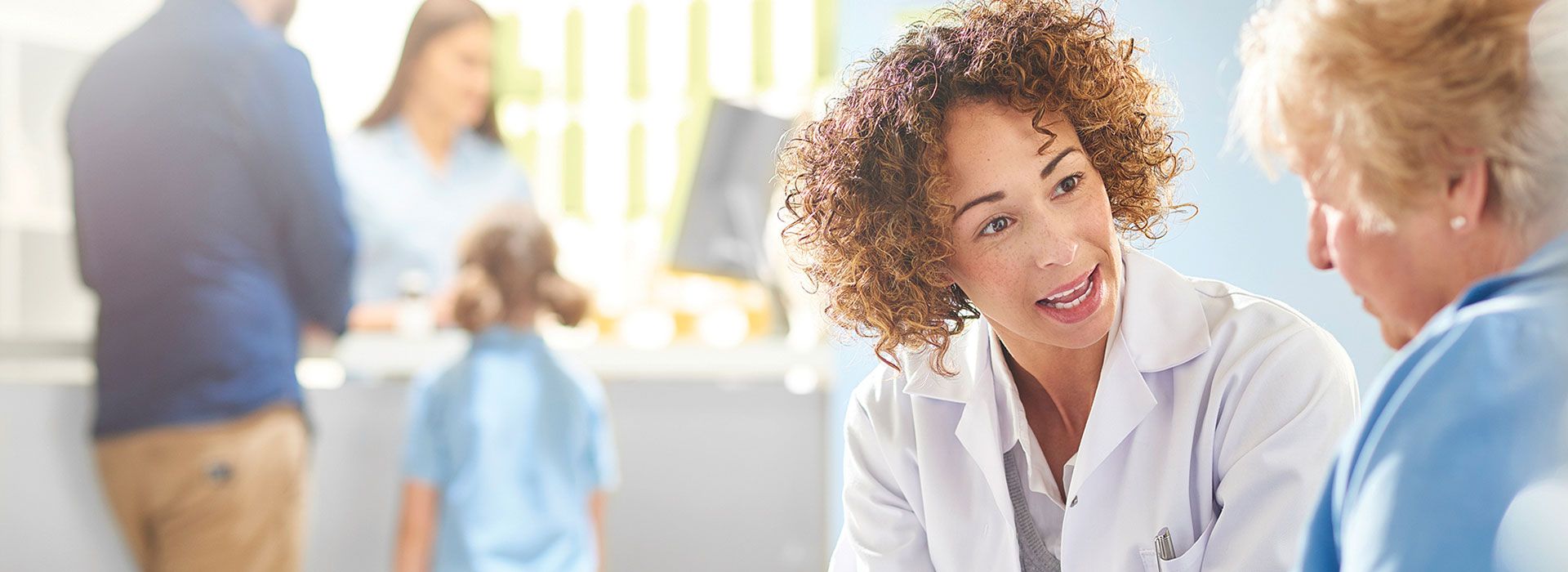 Audiologist offering hearing care advice to a woman in a clinic.