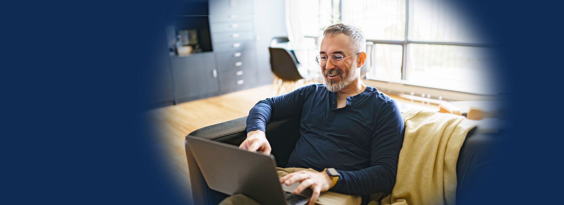 Man researching hearing aids and hearing loss on a laptop at home