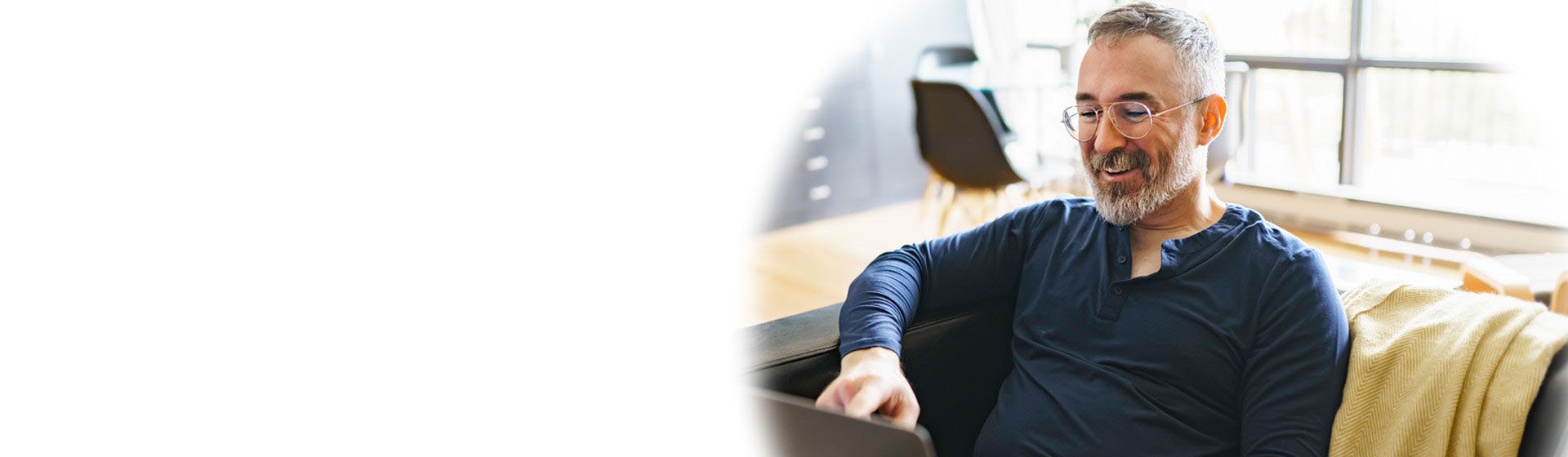 Man researching hearing aids and hearing loss on a laptop