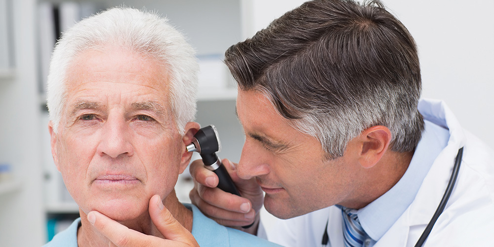 Audiologist performing an ear exam with an otoscope