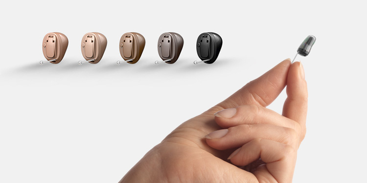 Woman holding Oticon Own Hearing Aid between fingers