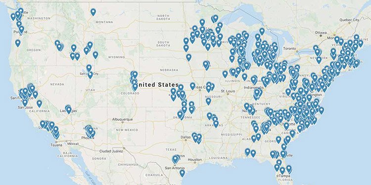 Map showing the United States, pinpointed with numerous blue location markers, mainly clustered in the eastern half, indicating various sites or points of interest across the country.
