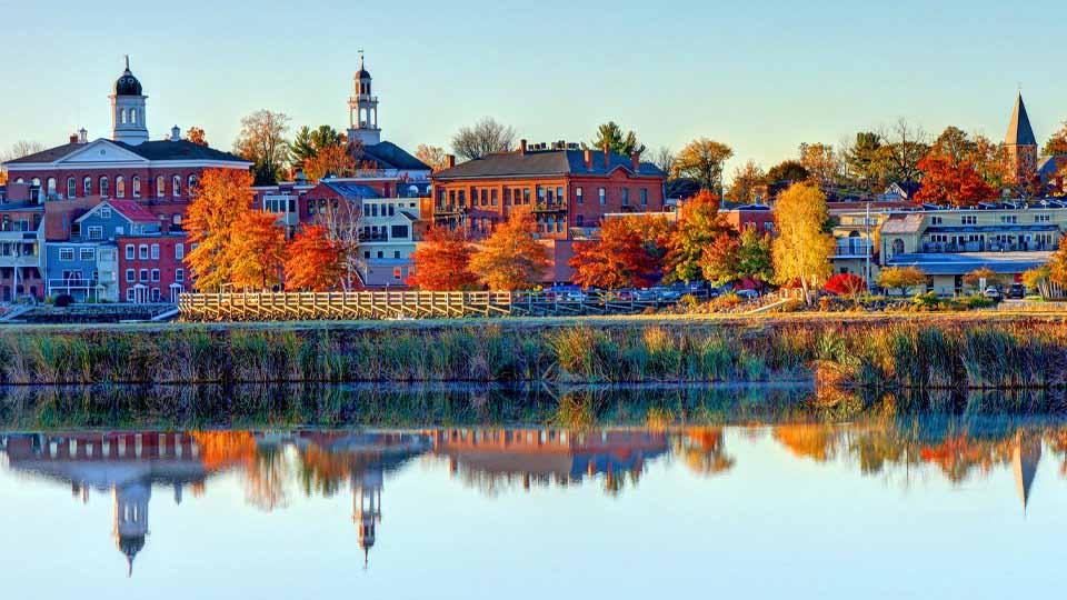 Portland skyline with colorful autumn trees reflected in a calm river.