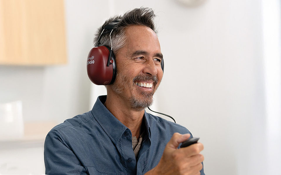 Smiling man receiving a free hearing test at HearingLife.