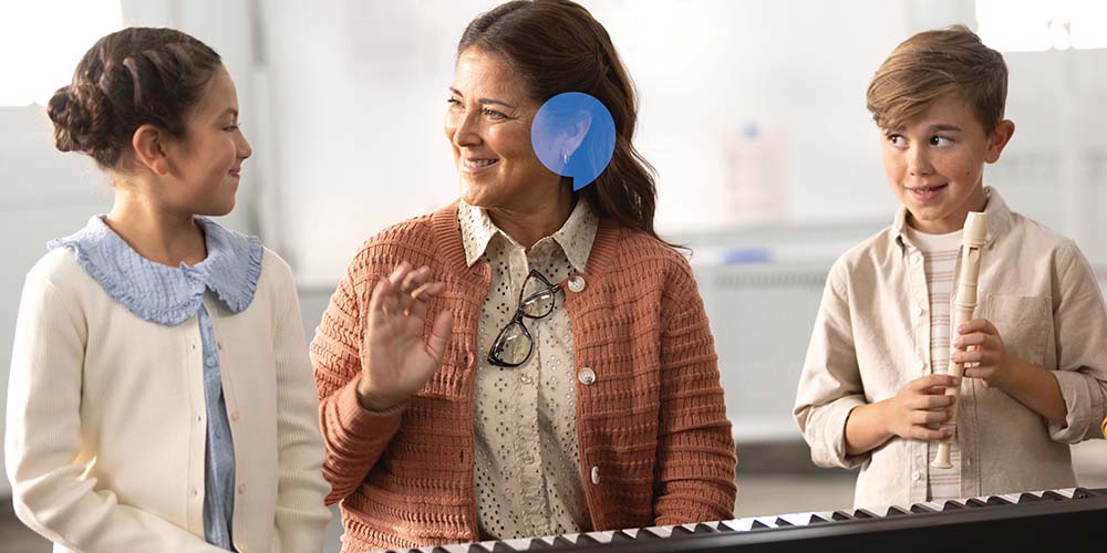 music teacher smiling as she hears her students play instruments