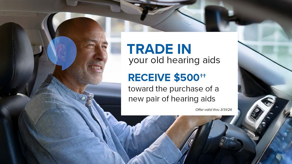 Trade in your old hearing aids RECEIVE $500†† toward the purchase of a new pair of hearing aids  Offer valid thru 3/31/26.  -- Man smiling and driving a car