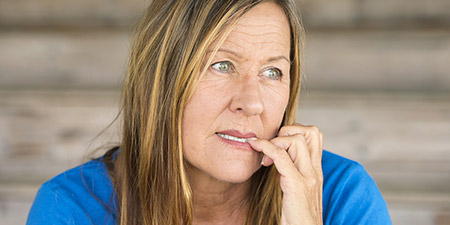 Woman in a thoughtful or upset mood wearing a blue shirt.