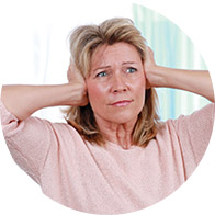 Woman covering her ears with both hands, possibly indicating discomfort or sensitivity to sound.