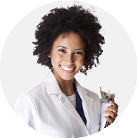 Female hearing care professional holding an otoscope wearing a white lab coat.